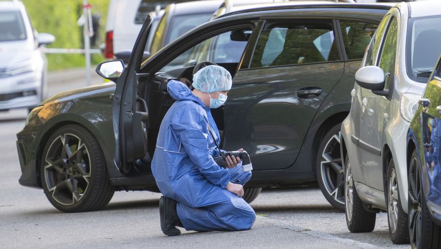 En kriminalteknikker knæler foran bilen, hvor den 35-årige blev skudt og dræbt. Foto: Kenneth Meyer